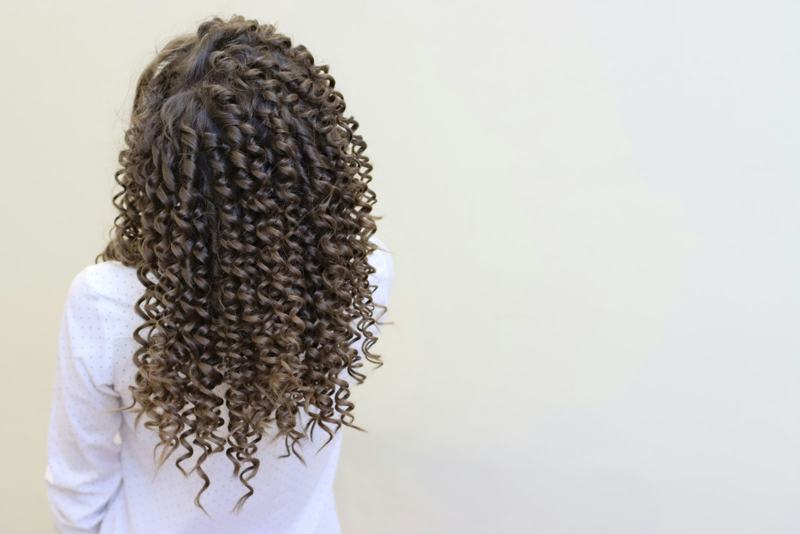 The back of long, defined curly hair falling past the shoulders