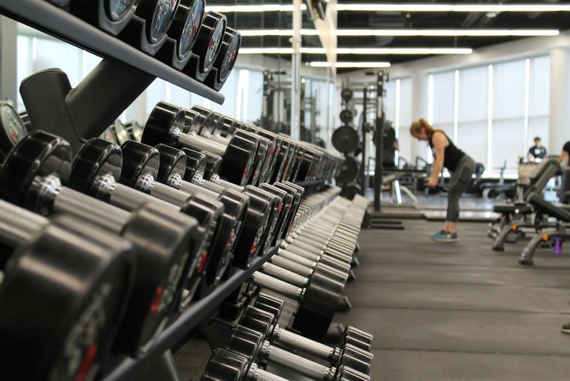 Long racks of dumbbells along a gym wall