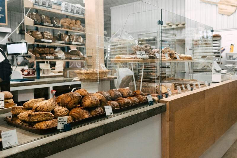 A bakery counter lined with pastries and shelves of bread