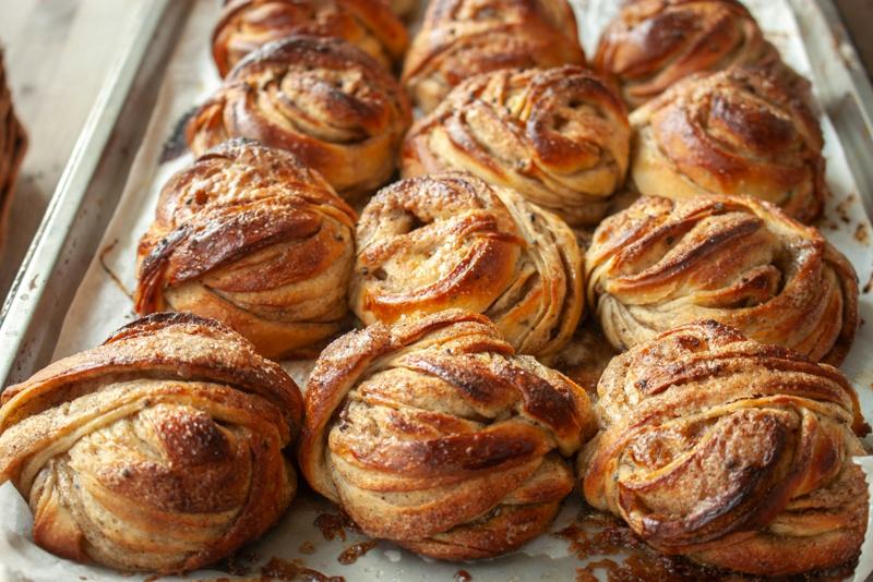 A baking tray of freshly baked cinnamon swirls with caramelized edges