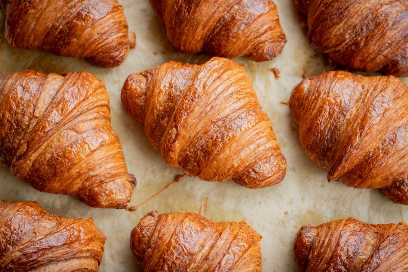 Rows of golden butter croissants on parchment