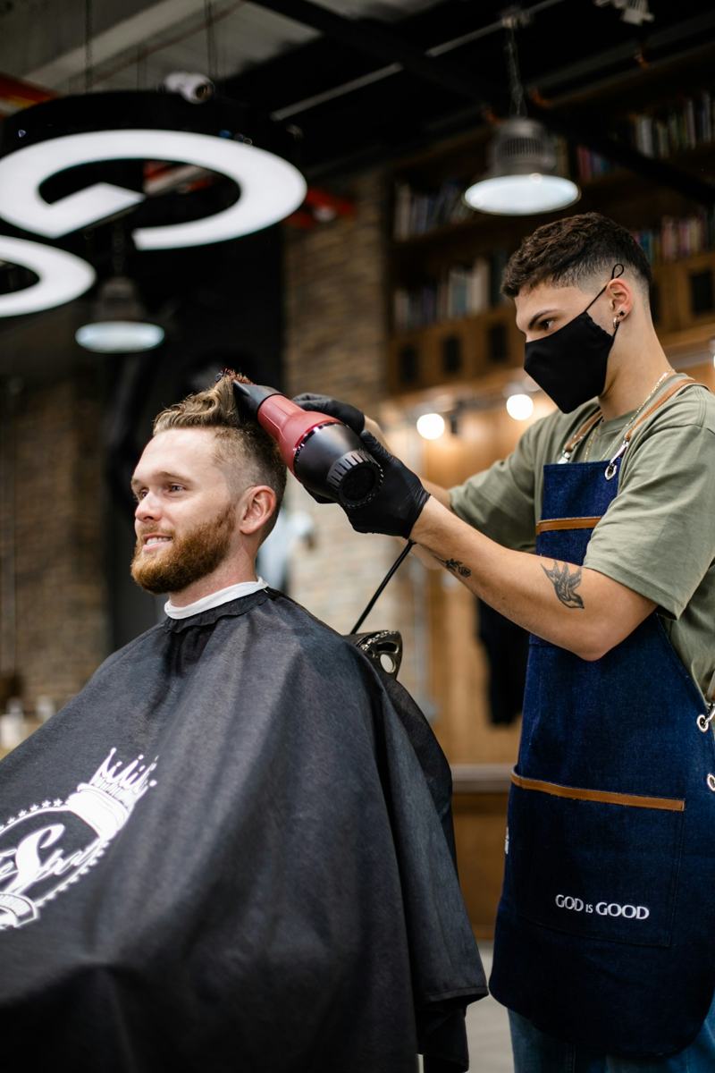 Barber cutting a client's hair with scissors
