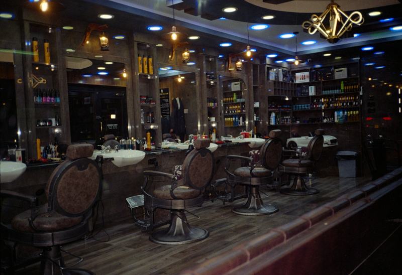 Dark barbershop interior with empty chairs